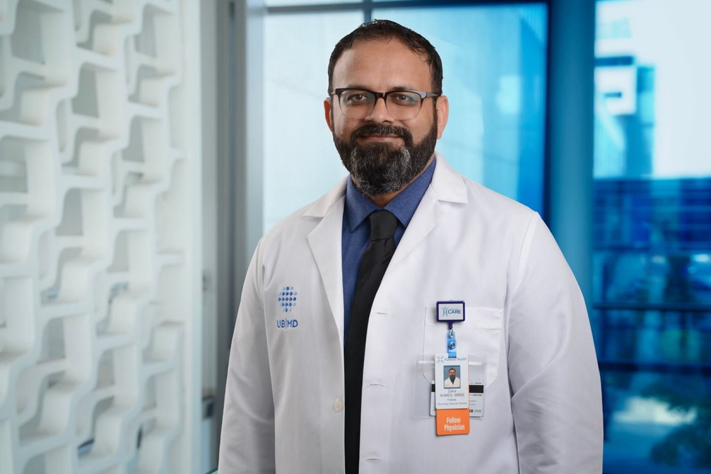 Zaka Ahmed, MD, vascular neurology fellow, in a white coat at the Gates Vascular Institute, University at Buffalo.